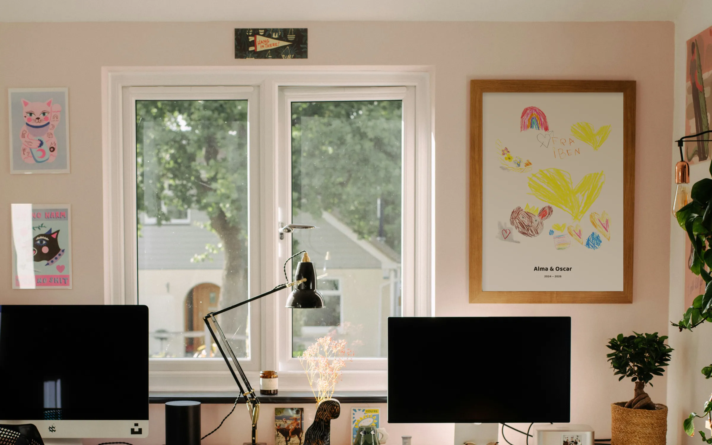 Posters of children's drawings on the wall of a home office